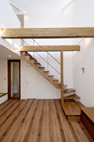 【リビング】開放的な吹抜空間に表しの木製梁と木製階段がバランスよく配置されています。